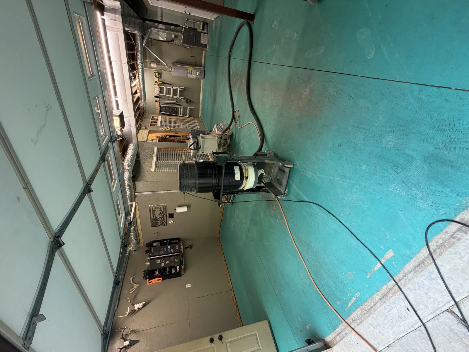 Two dust extractors working in a garage with the old teal floor paint still down