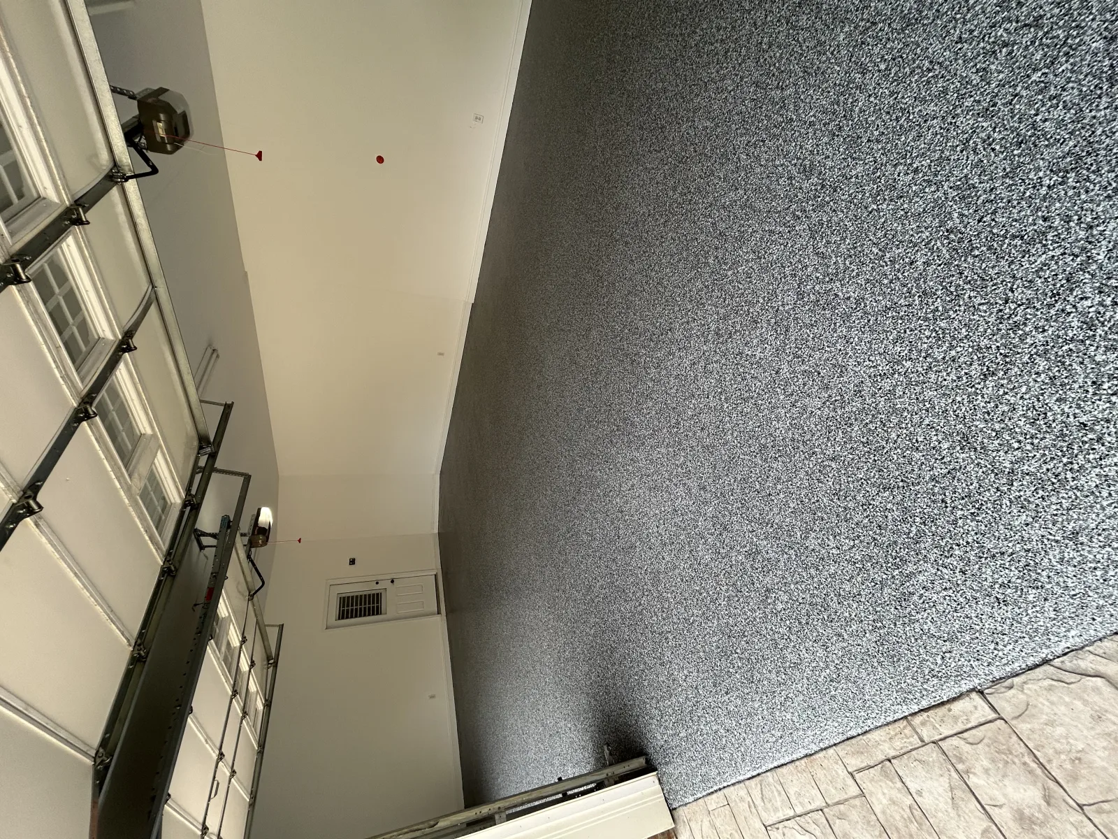 Bare patched slab in a boiler room with hoses laid out before coating