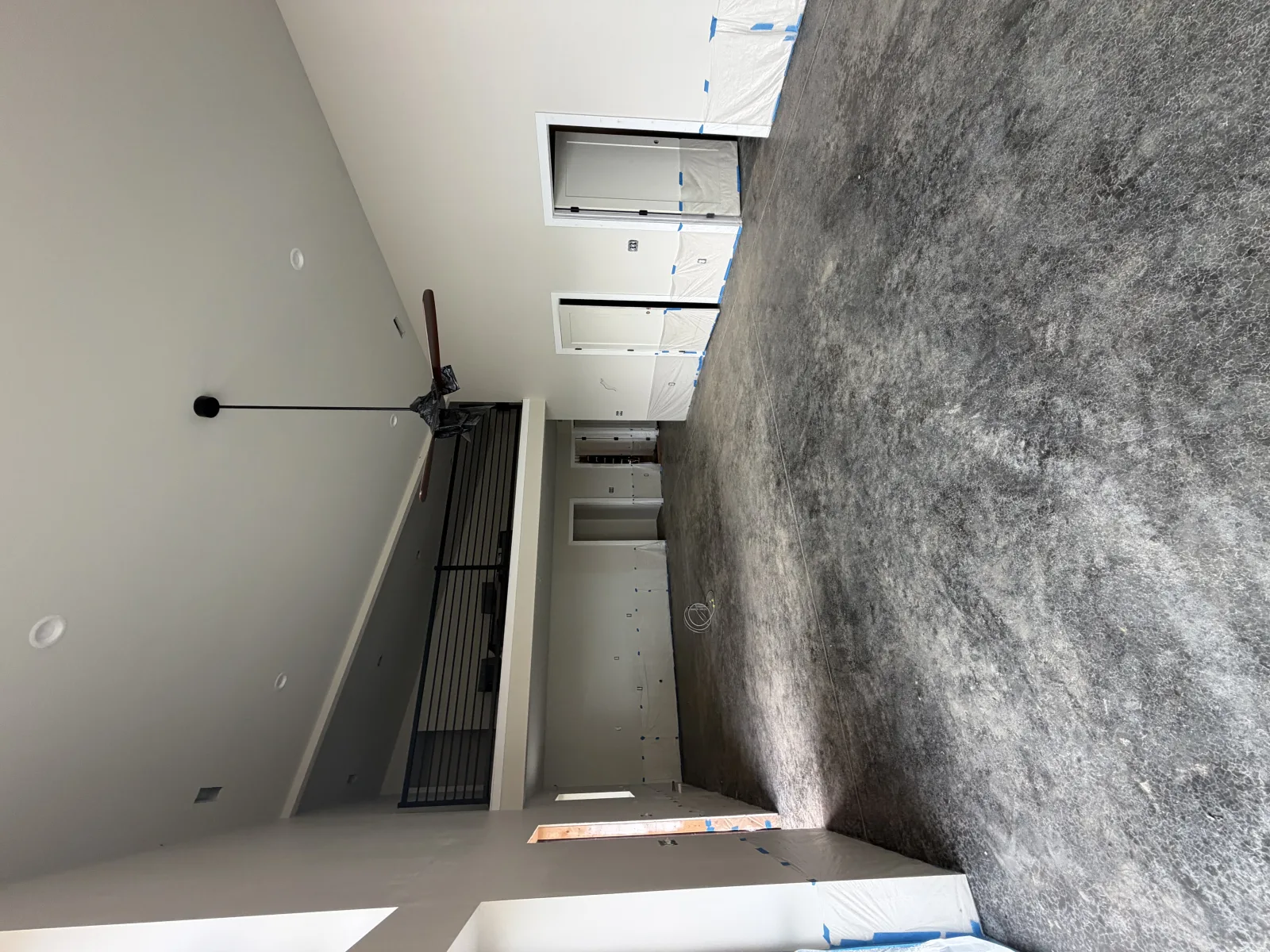 Warm brown stained floor across a double-height room with a loft rail above