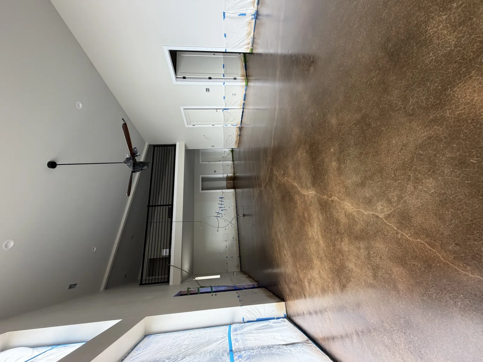Stained concrete floor seen from the loft above, saw-cut into panels