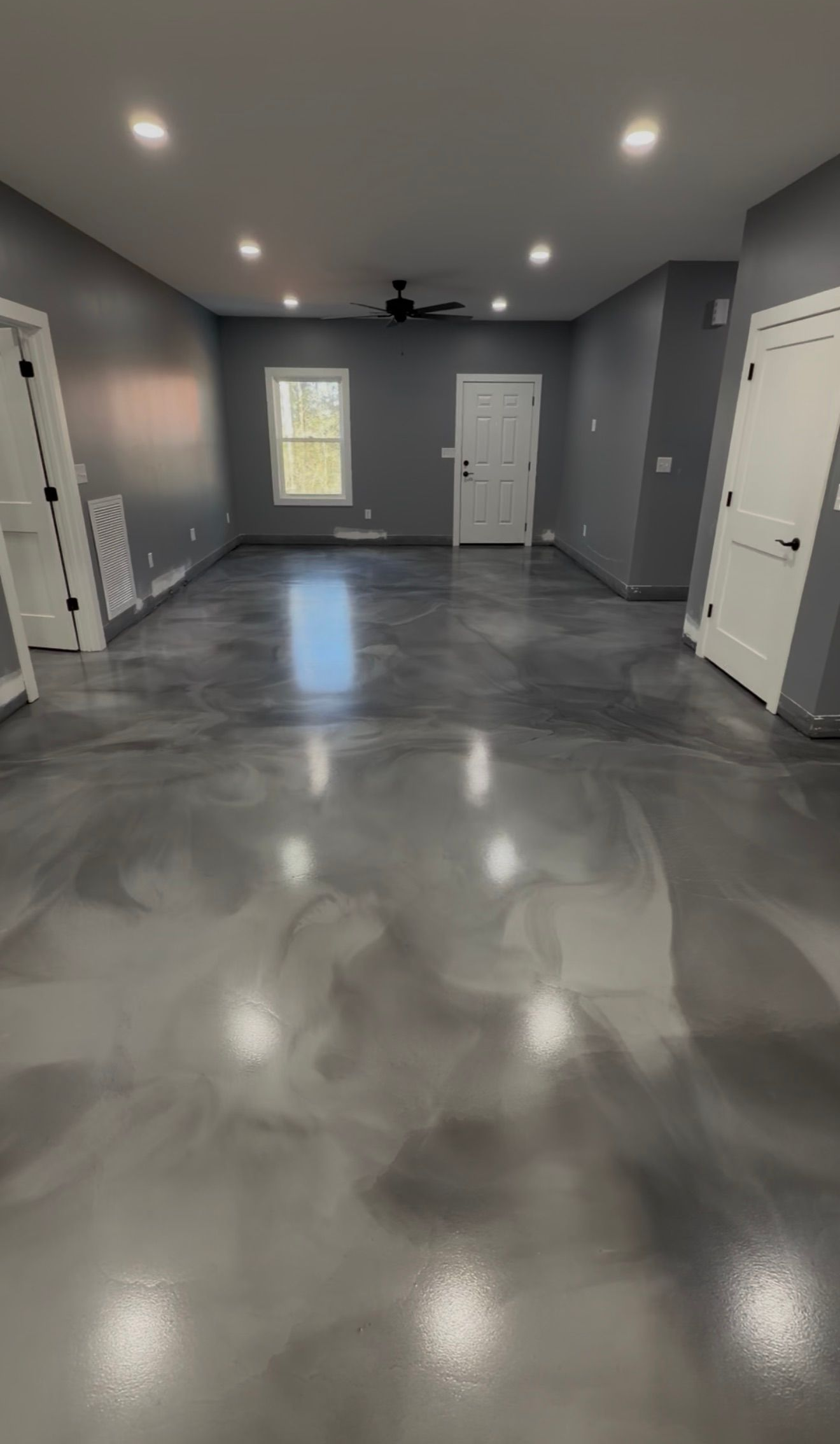 Pewter metallic epoxy floor with flowing pearl movement in a finished basement room