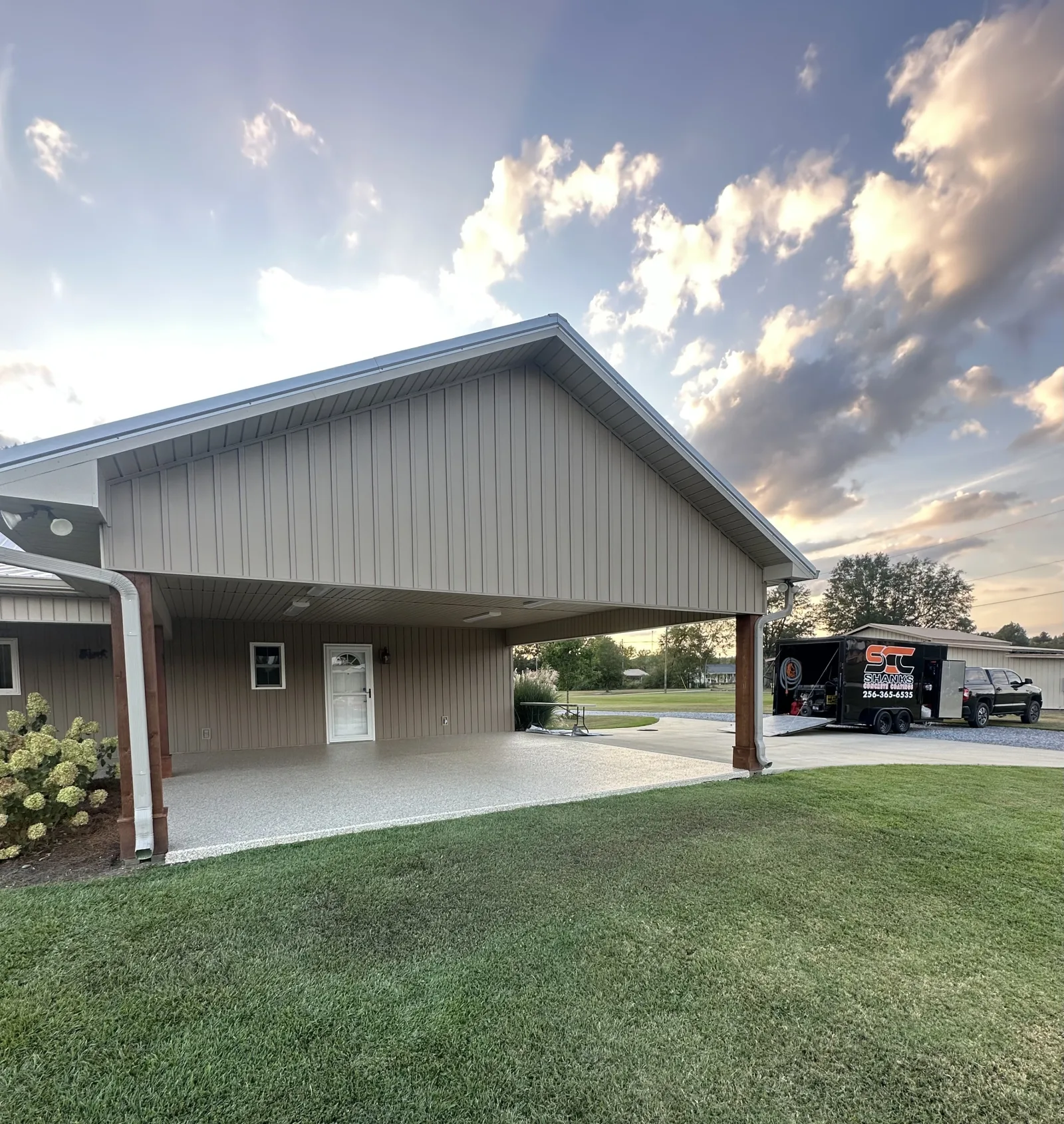 Gabled carport at dusk with the Shanks trailer parked at the far end