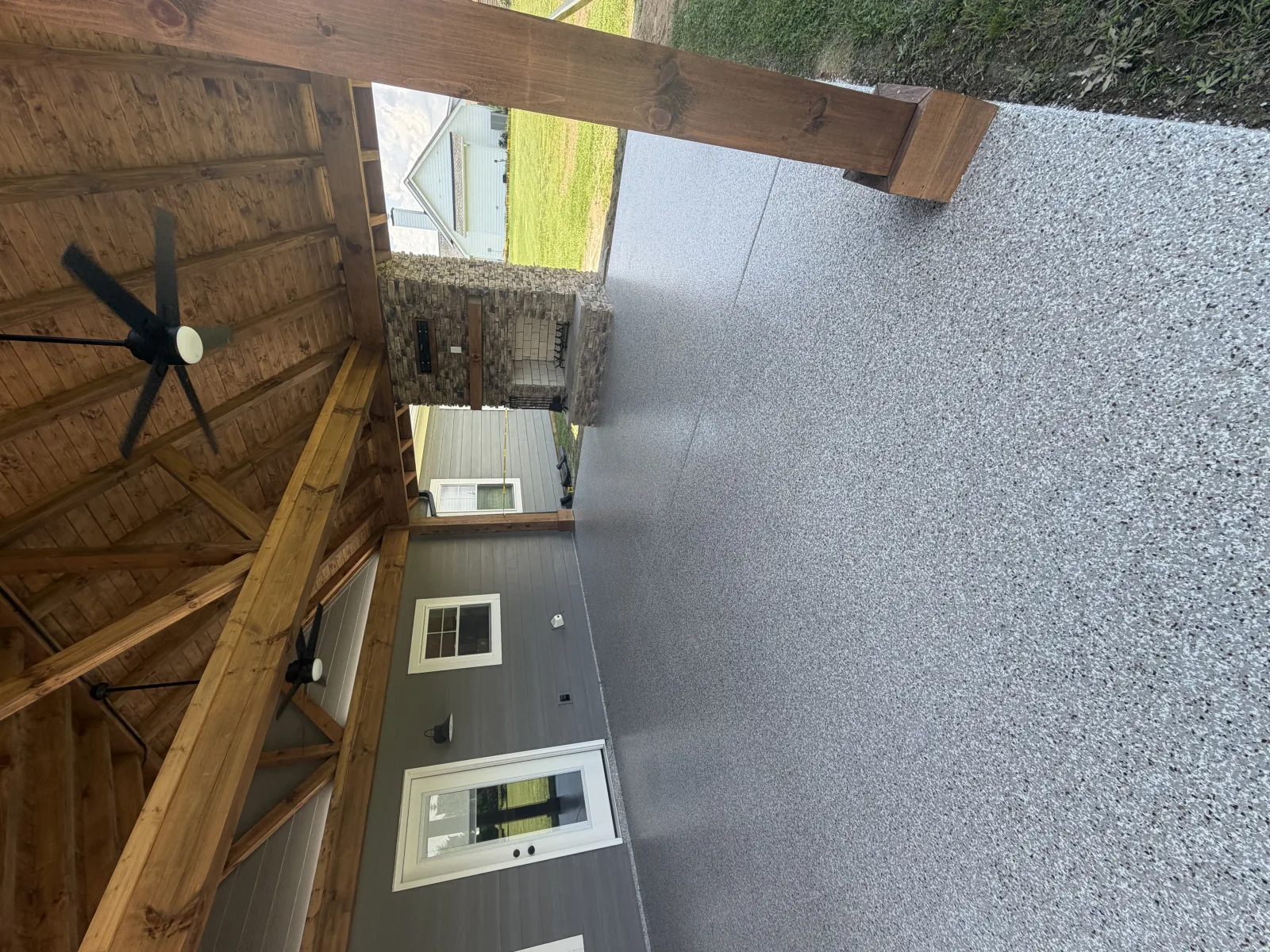 Sealed concrete floor throwing back the light from a black-framed window wall